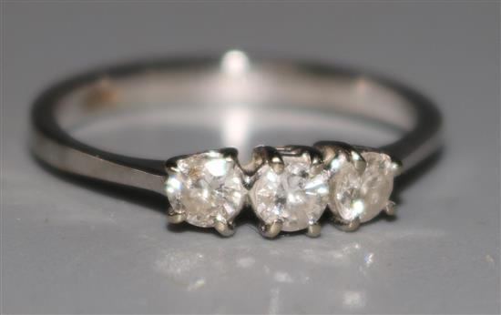 An 18ct gold and three stone diamond ring, size M.